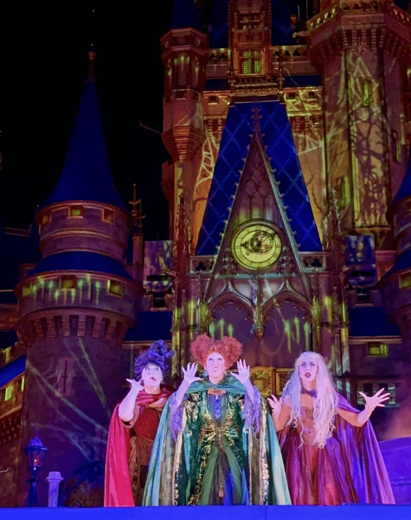 The Sanderson Sisters take center stage in front of Cinderella's Castle for Mickeys Not-So-Scary Halloween Party